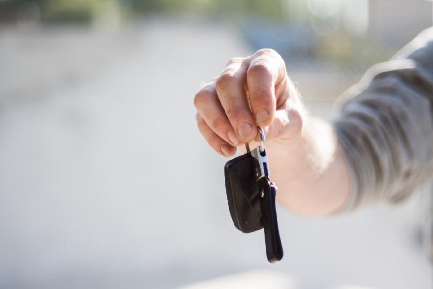 Une main tend une clé de voiture.