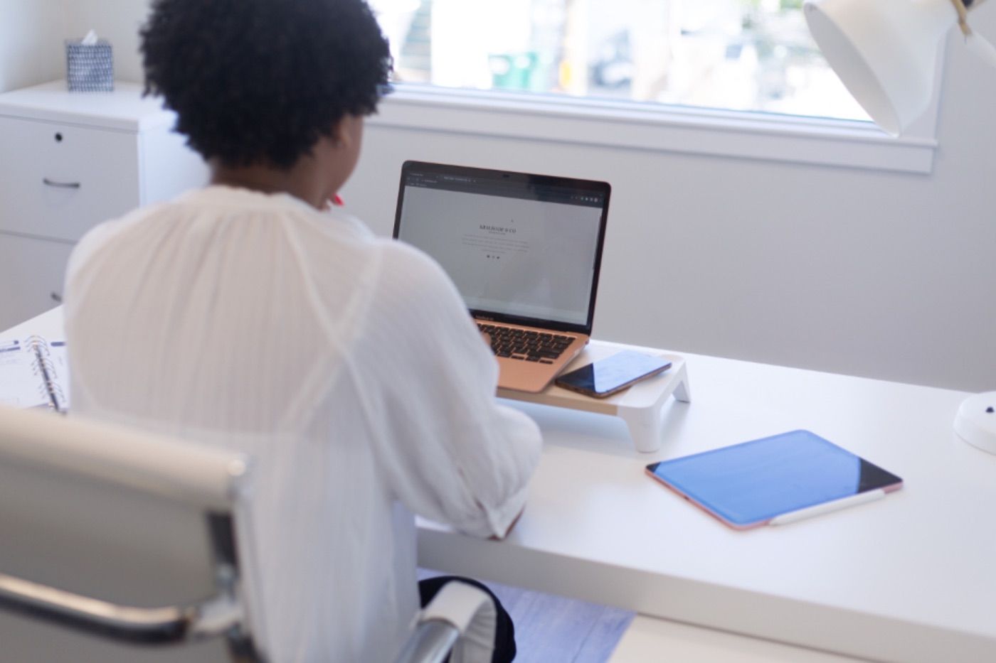 Une courtière travaille à son bureau, devant son ordinateur.